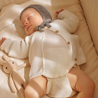 Why do babies sleep with their arms up?